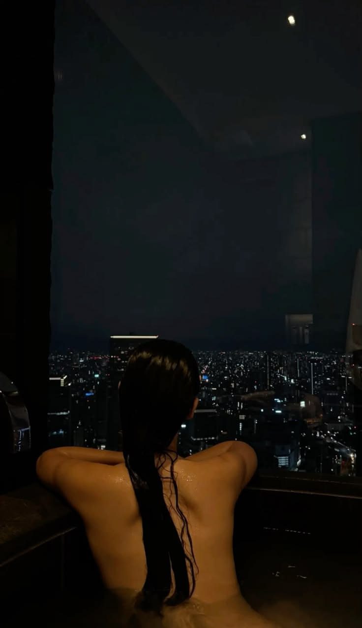 A bare back in the night bath, the city below